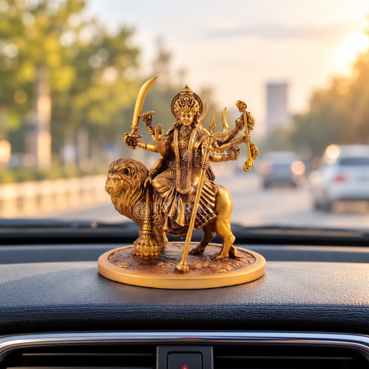 Goddess Durga lion statue displayed on a car dashboard