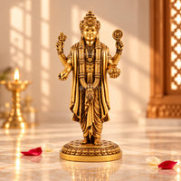 Lord Dhanvantari idol with golden finish displayed in a devotional setting