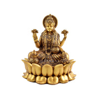 Goddess Lakshmi idol sitting on lotus flower with detailed golden artwork